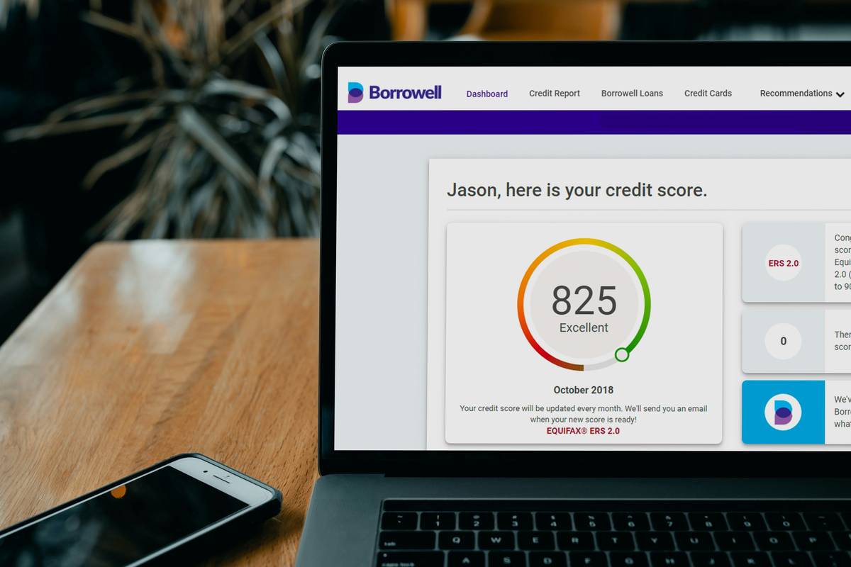 Two hands signing a joint credit card application insights form with pens on a wooden table